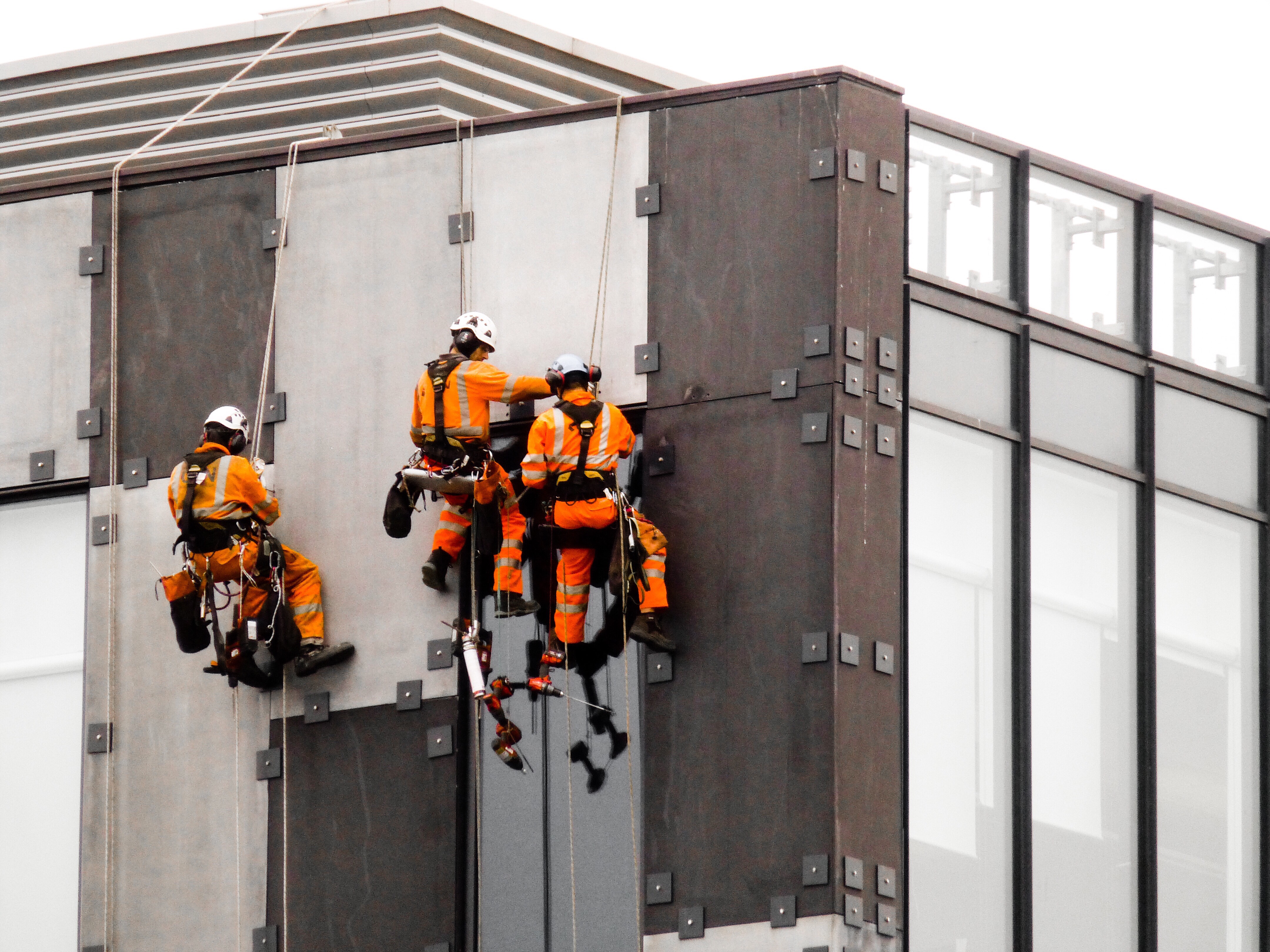 Workers in safety working uniform working at height where there is compliance with working at height regulations 2005.